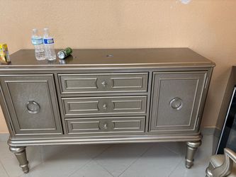 high-end metallic champagne/silver credenzas, dressers, and sideboards typically list between $300 and $750 depending on the specific brand and local