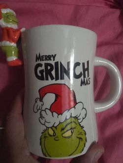 new Merry Grinchmas White Ceramic Mug with the grinch character hanging over rim