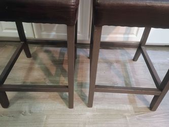 4 brown, heavy, solid wood counter height chairs.