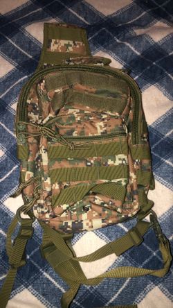 Used tactical backpack featuring a digital woodland camouflage pattern and MOLLE webbing.