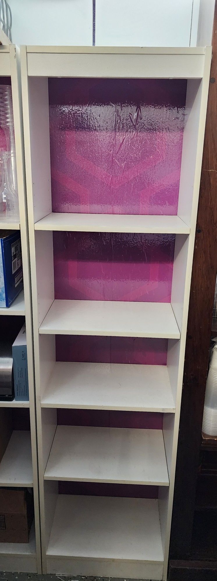 2 White Book Shelves With Purple Background