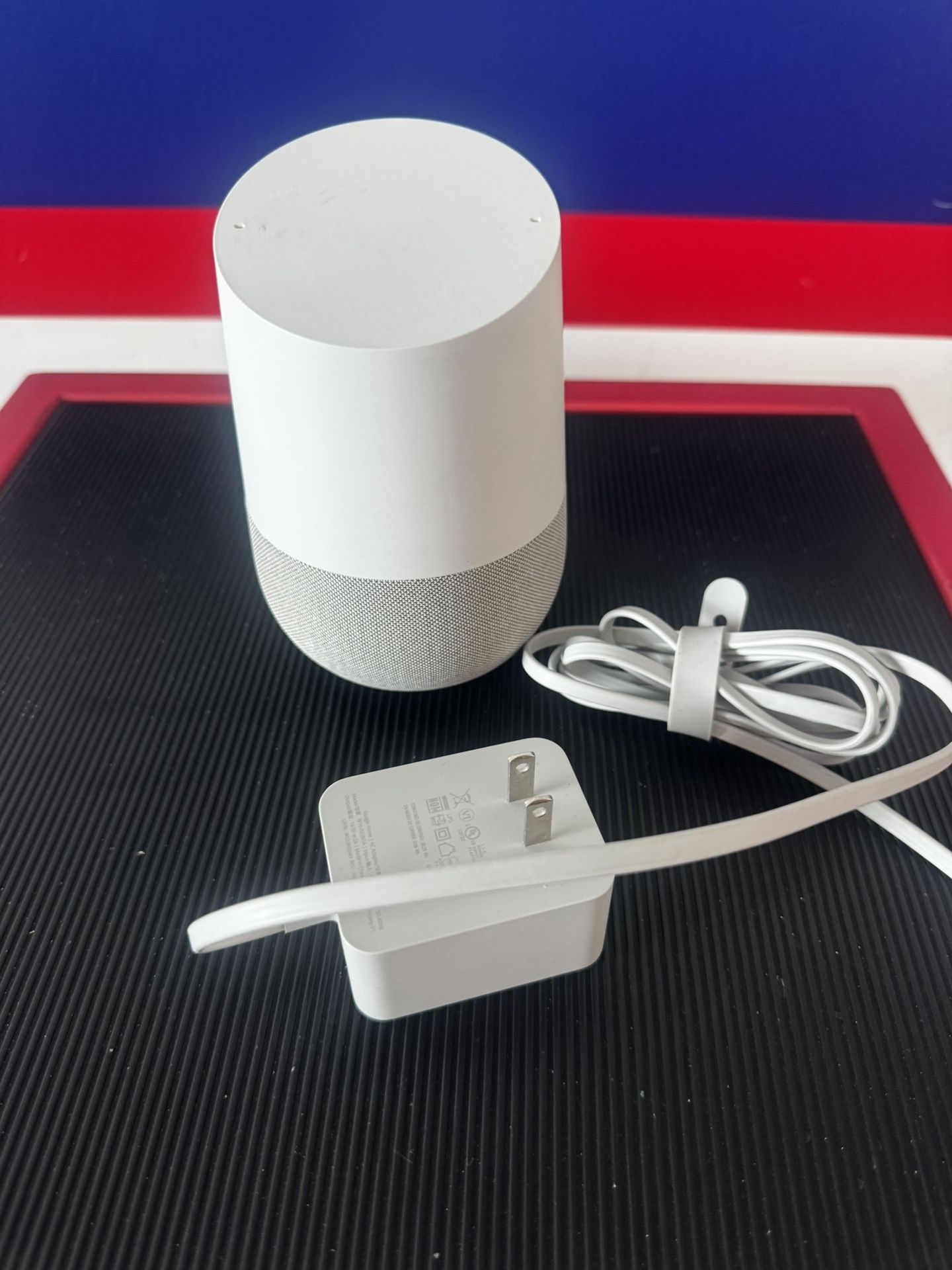 Google Home (1st Gen) smart speaker with its original power adapter.w