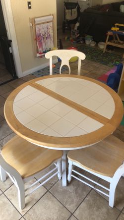 White round table with leaflet and 3 chairs