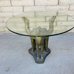 Vintage Three camel-form side table featuring a sculptural base and a circular glass top.