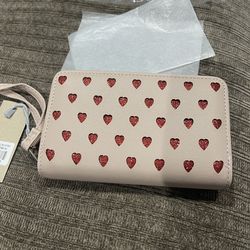 Wristlet wallet with zip-around and magnetic snap closure.