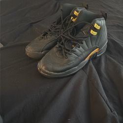 black and gold Air Jordan 12 Retro Mid 'Black Taxi' sneakers. 