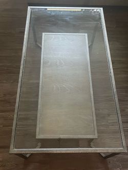 Modern glass coffee table with metal frame and storage shelf