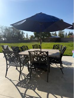 Black cast iron/tavertine table and 8 chairs