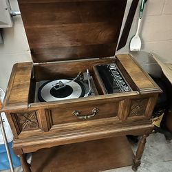 This is a vintage General Electric (GE) stereo console with a built-in record player and radio receiver.