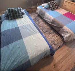 Twin beds with mattresses and sheets