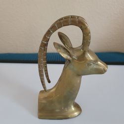 Vintage brass ibex or gazelle head sculpture, often used as a bookend or decorative accent