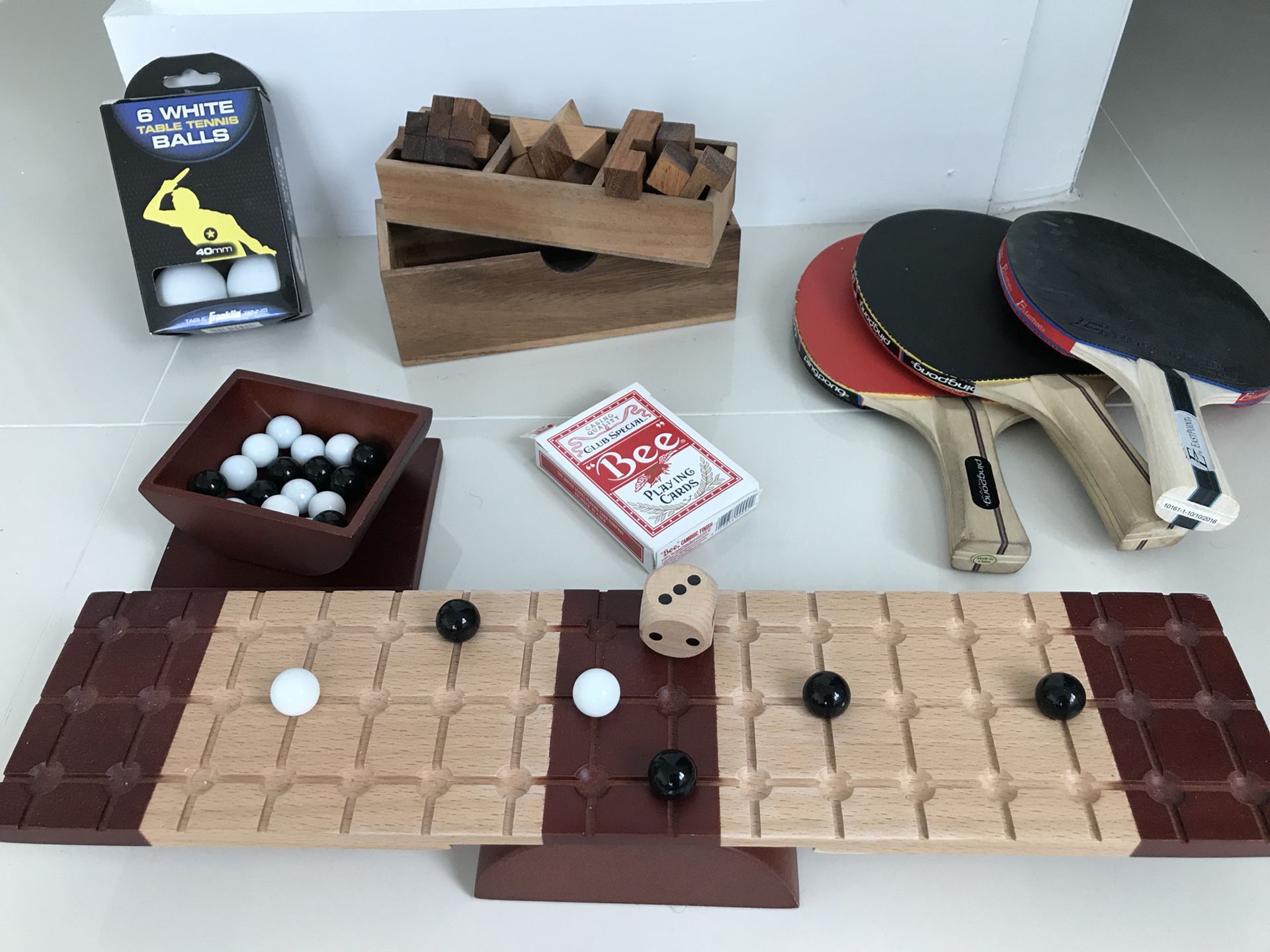 Wooden puzzles, playing cards, pin pong balls and paddles, marble game