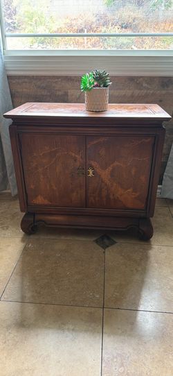 Beautiful carved wood cabinet with unique Asian-inspired design.