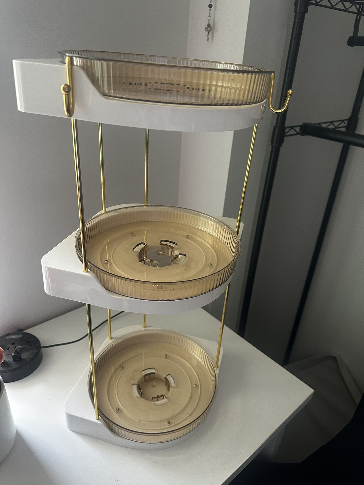 Gold and white tiered storage unit with rotating trays