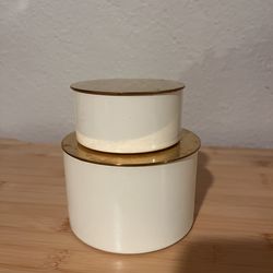 Round cylindrical gold and white storage containers