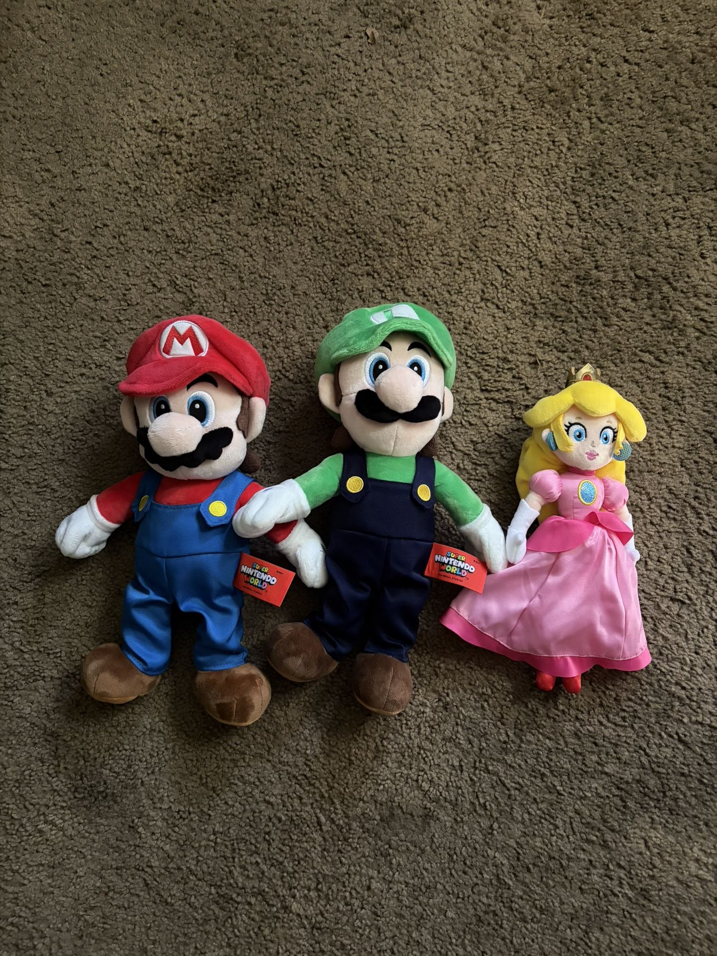 Mario, Luigi, and Princess Peach Plushies from Super Nintendo World