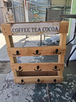 Farmhouse cup holder with a cups for the top and hanging on the tooth.