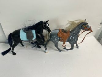 Two toy horses with saddles and bridles