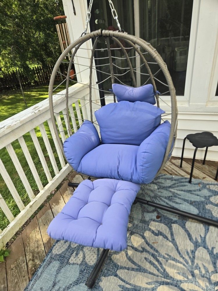 hanging egg chair with a stand and a detachable footrest.