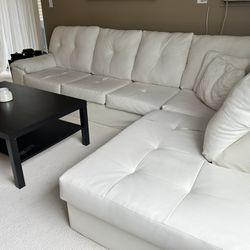 White sectional sofa and black table