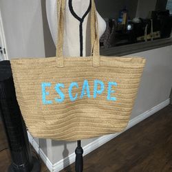 over-sized straw tote beach bag with "ESCAPE" embroidered in blue