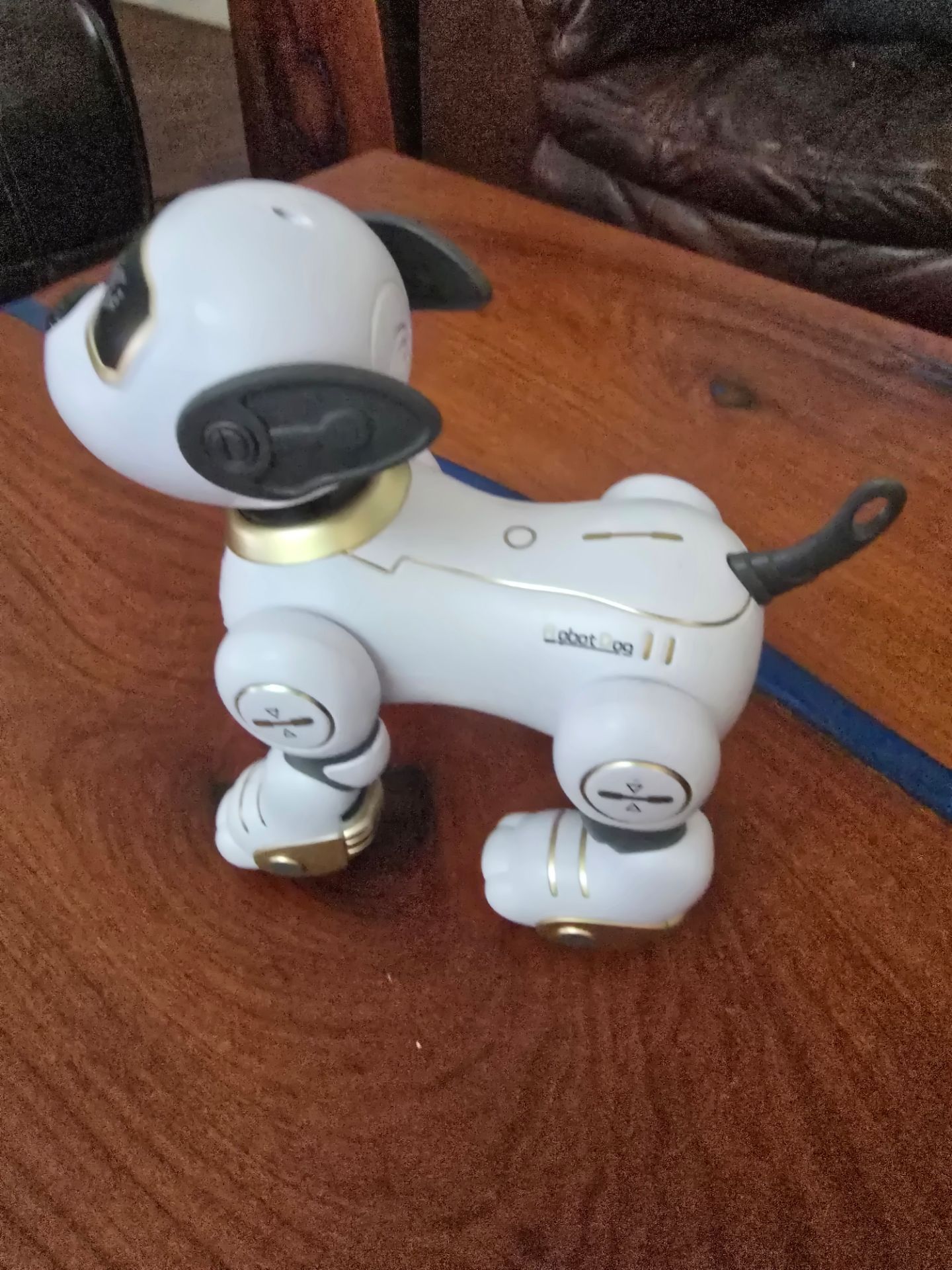 Interactive robotic dog in white with gold and gray accents. Smooth plastic body and movable legs. Modern futuristic look. Great collectible or play t