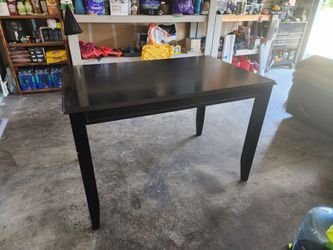 Wooden table w/ leaf and 4 metal chairs.