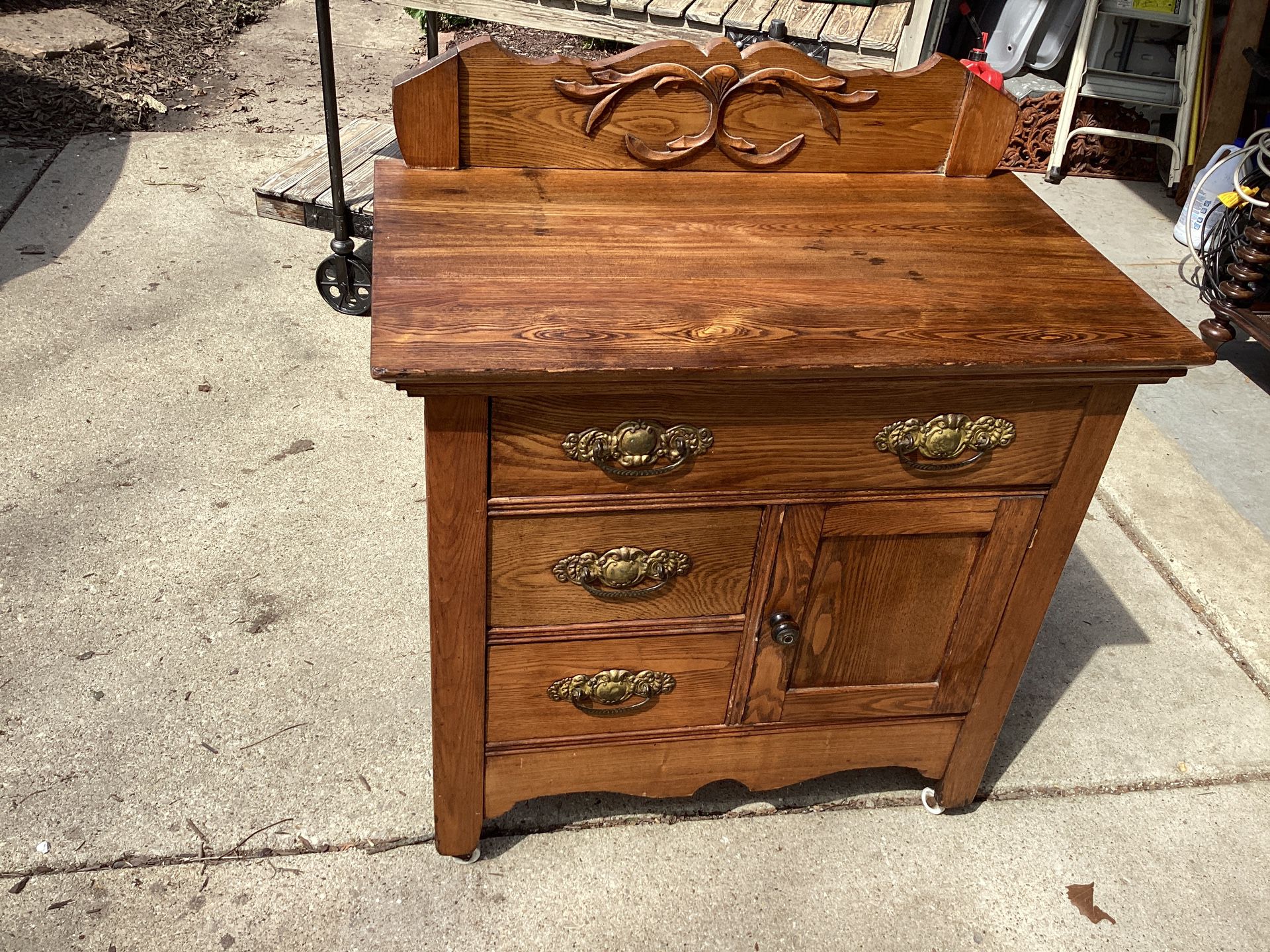Vintage cabinet original pulls barn wood carved 3 drawers 1 door opens storage on casters …30.5  long—- 18 deep —- 32 tall. This is Americana treasure