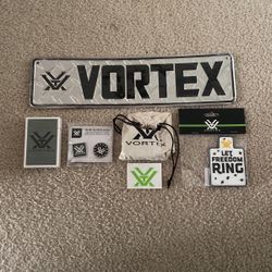 Brand new metal vortex sign, unopened playing cards, pins ,stickers ,dice and a Velcro patch