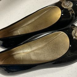 Pair of Young Versace sneakers in black patent leather with Medusa head medallions.