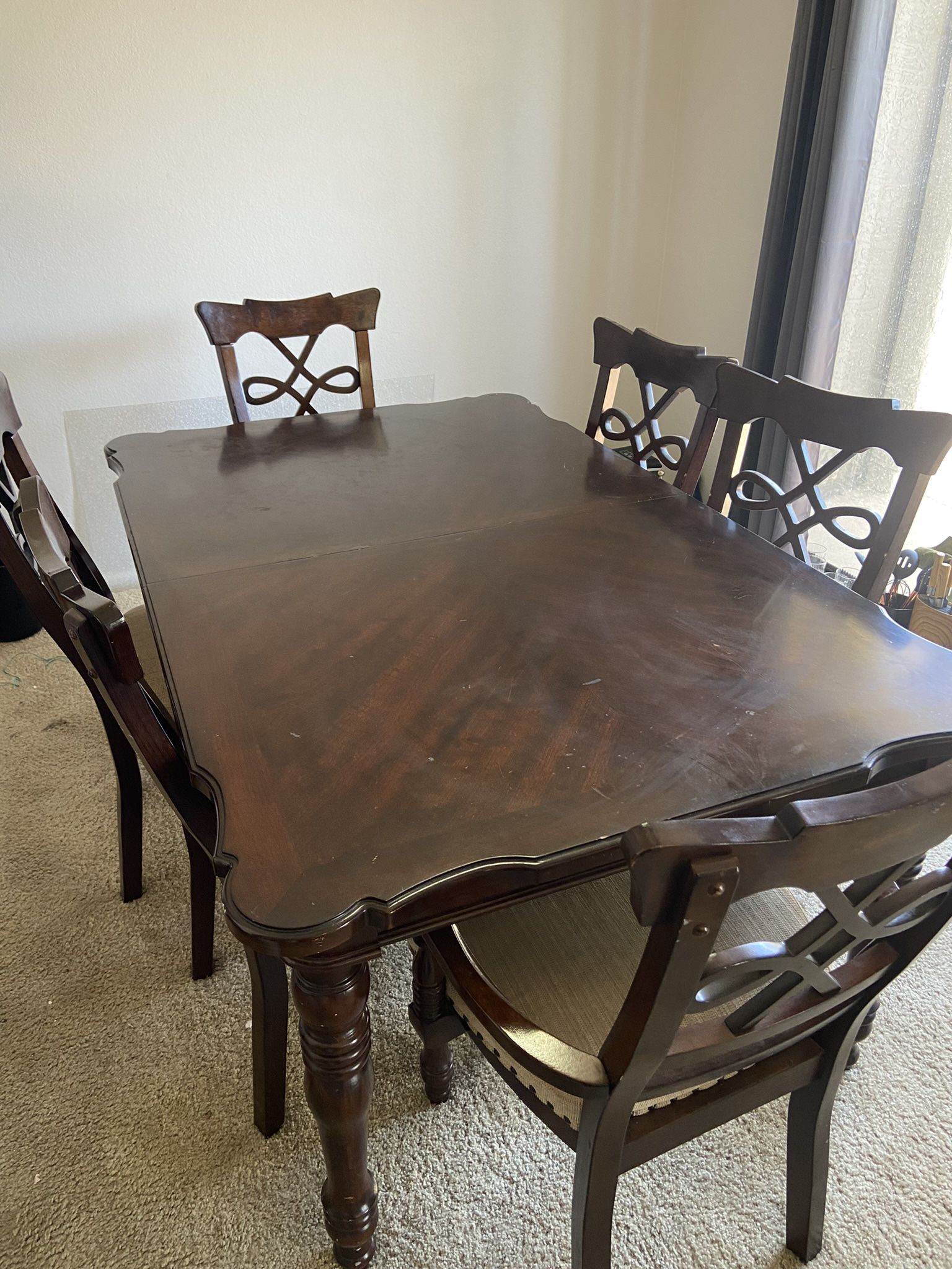 Large brown wood table with chairs and extender