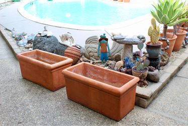A pair of oversized terracotta planters, mark “Avilas / G. A.”