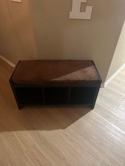storage bench has a dark brown wood-finish frame