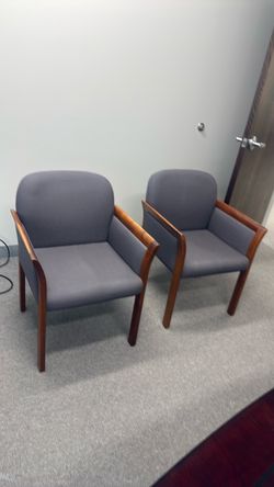 Two gray fabric chairs with wood