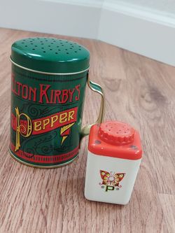2 Pepper Shakers. 1 Metal ELTON KIRBY by NORPRO 1 Biege & Orange Plastic with P and Butterfly Design