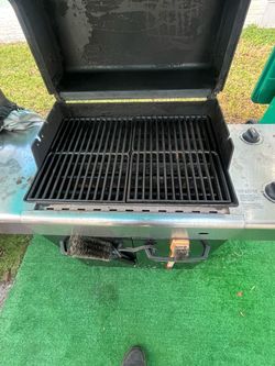 Weber, gas grill has new grates on the inside and a tank of fuel
