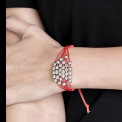 silver beads are threaded along row after row of shiny red cording around the wrist $5