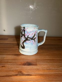 This handcrafted ceramic mug from Natalie Reed Studio Pottery features a hand-painted cherry blossom design.