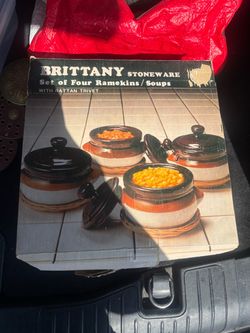 Vintage Brittany stoneware four ramekins/soups with lid, orange-brown ceramic, on wood with rattan trivets.