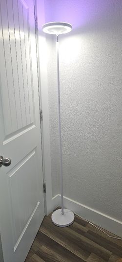 LED floor lamp with multicolor options, remote control, and smartphone compatibility. Round head design with adjustable white light settings.