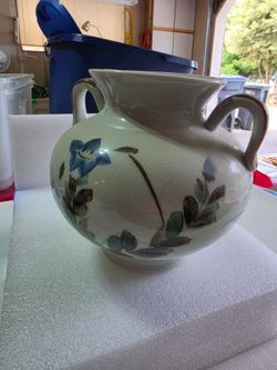 The piece is a vintage double-handled ceramic vase or amphora jar