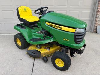 John Deere X310 tractor and total yard care package (snow blade, yard sweeper, and aerator)