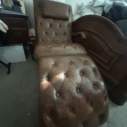 Tufted leather armchair with a matching ottoman.
