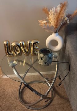 Glass side table with silver metal. Base