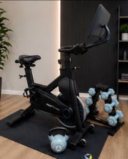 MYX Fitness Bike with 21.5 inch touchscreen plus weights, rack, and mat.