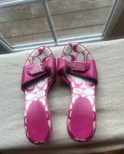 pink Coach signature kitten heel slide sandals with a buckle detail.