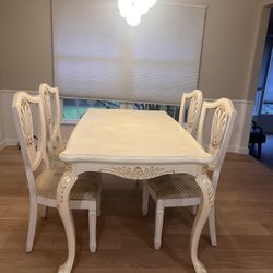 Beautiful white dining table with 4 matching chairs featuring classic carved details and an elegant, traditional design