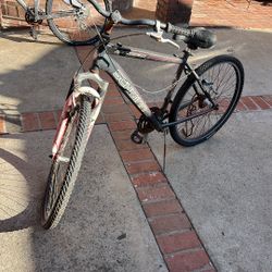 The image features a Schwinn Sidewinder mountain bike.  It is a 26-inch men's mountain-style bicycle. The bike includes front suspension forks. It is 