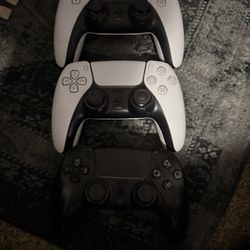 2 White Ps5 Controllers And 1 Black One