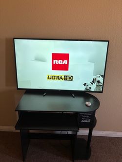 RCA ULTRA  HD 42” TV WITH WOODEN BLACK TABLE